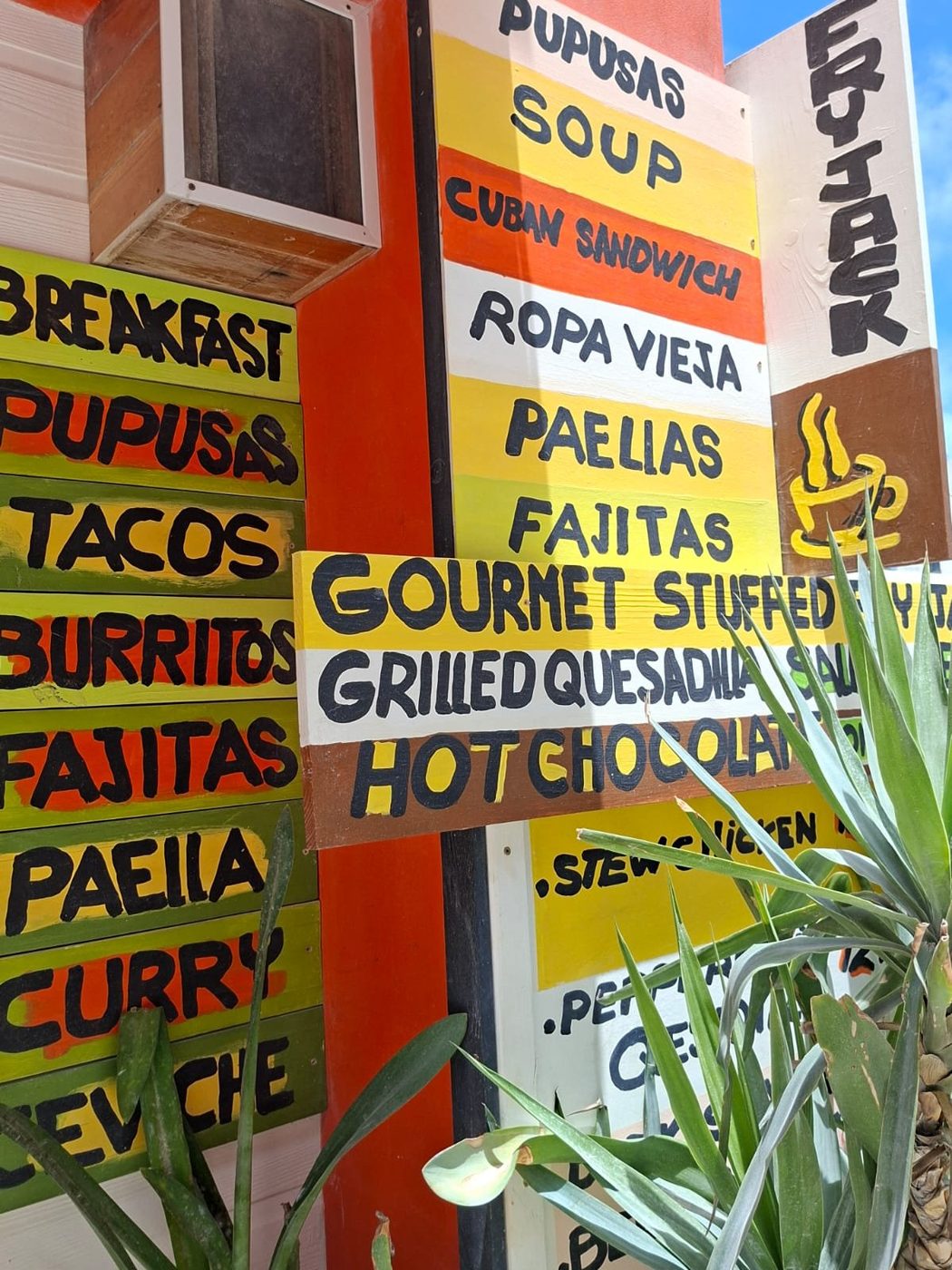 Colorful hand-painted signs listing La Cubana's dishes