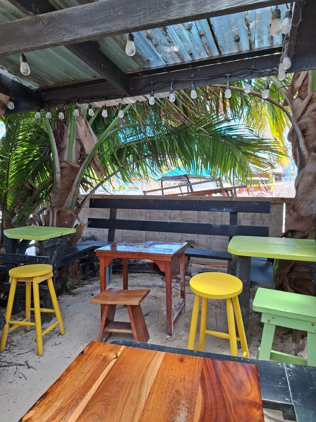 Open-air seating on the sand under string lights at La Cubana, Caye Caulker